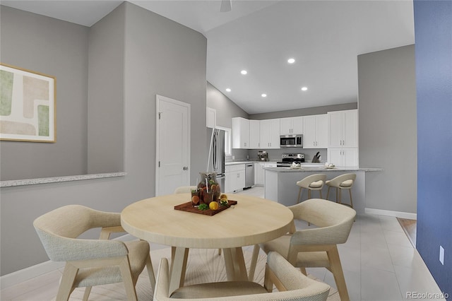 dining room with recessed lighting, baseboards, light tile patterned flooring, and vaulted ceiling