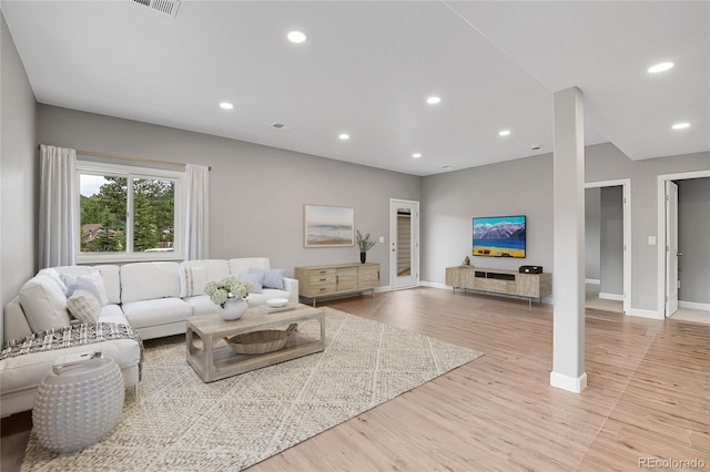 living room with recessed lighting, baseboards, and light wood-style floors