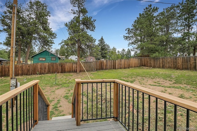 deck with a lawn and a fenced backyard