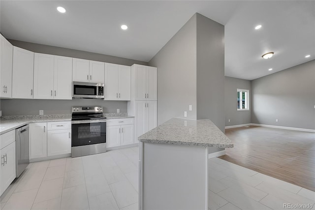 kitchen with white cabinetry, light stone counters, recessed lighting, and appliances with stainless steel finishes