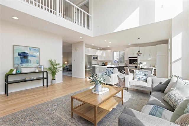 living room featuring a high ceiling and light hardwood / wood-style flooring