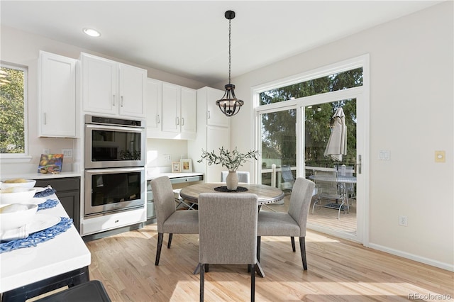 dining room featuring a wealth of natural light, light hardwood / wood-style flooring, and an inviting chandelier