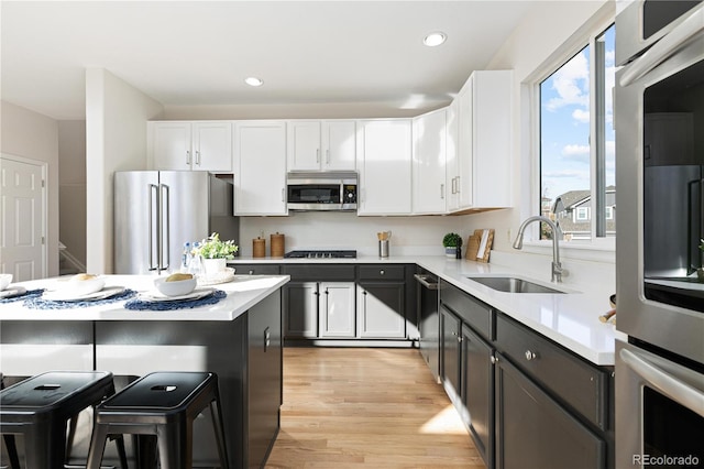 kitchen with white cabinets, a kitchen island, sink, and appliances with stainless steel finishes