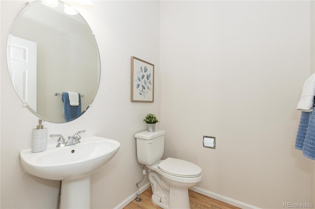 bathroom with hardwood / wood-style floors and toilet