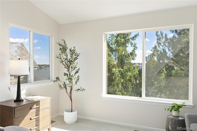 sitting room with carpet floors, a water view, vaulted ceiling, and a healthy amount of sunlight