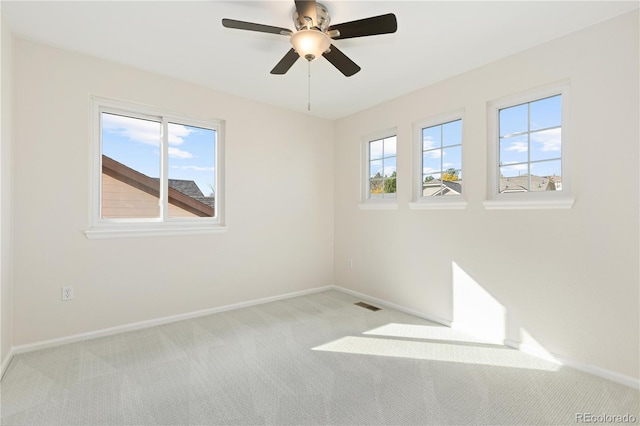 empty room featuring light colored carpet and a healthy amount of sunlight