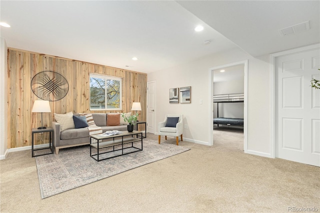 living room with wooden walls and light carpet