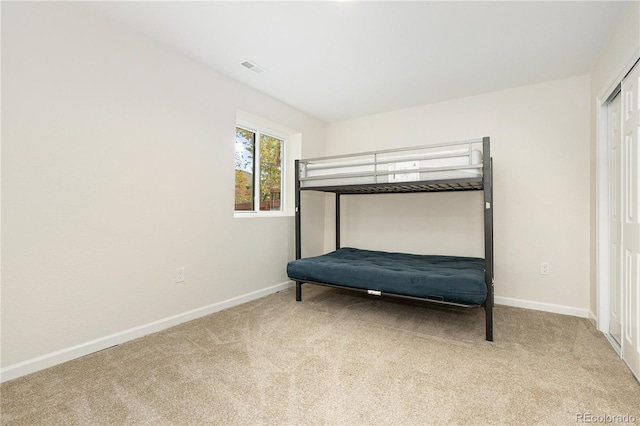 unfurnished bedroom with light carpet and a closet