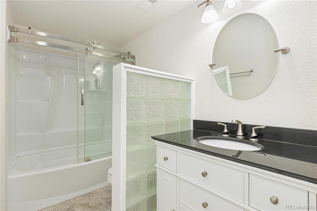 full bathroom featuring tile patterned flooring, toilet, combined bath / shower with glass door, and vanity