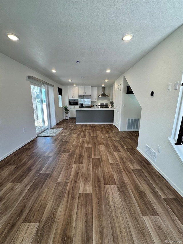5060 N Walden Way, Denver, CO 80249 - unfurnished living room featuring dark wood-style floors, baseboards, a textured ceiling, and recessed lighting