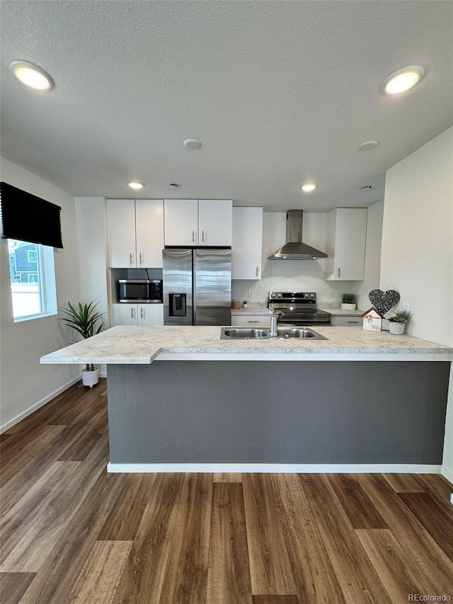 5060 N Walden Way, Denver, CO 80249 - kitchen featuring appliances with stainless steel finishes, wall chimney range hood, white cabinetry, light stone countertops, and dark wood-type flooring