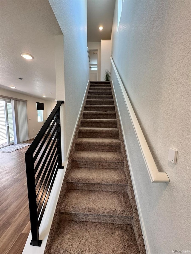 5060 N Walden Way, Denver, CO 80249 - staircase featuring a textured wall, recessed lighting, baseboards, and wood finished floors