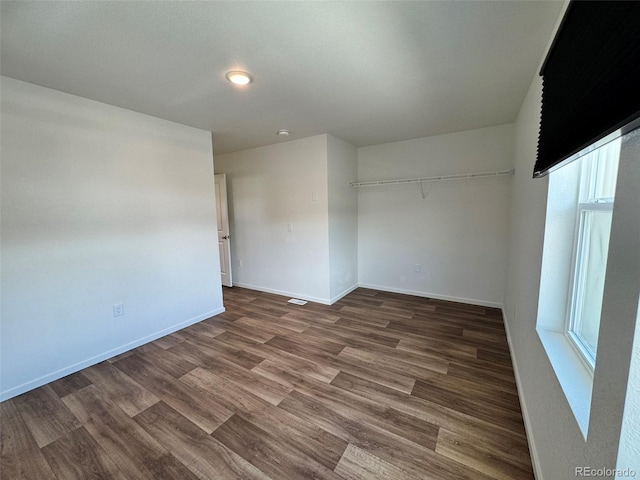 5060 N Walden Way, Denver, CO 80249 - unfurnished bedroom with baseboards and wood finished floors