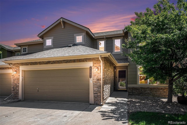 22002 E Irish Dr, Aurora, CO 80016 - view of front of house with stone siding, an attached garage, concrete driveway, and a shingled roof
