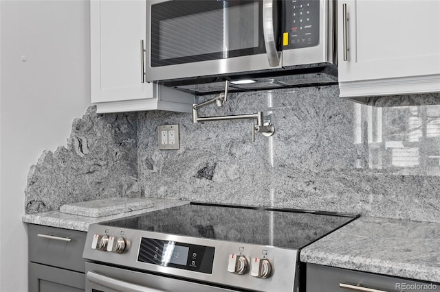 320 S Ames St Unit 5, Lakewood, CO 80226 - kitchen view of appliances with stainless steel finishes, pot filler, decorative backsplash, white cabinetry, and gray cabinetry
