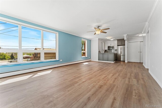 320 S Ames St Unit 5, Lakewood, CO 80226 - unfurnished living room with crown molding, a baseboard heating unit, ceiling fan, light wood-type flooring, and baseboards