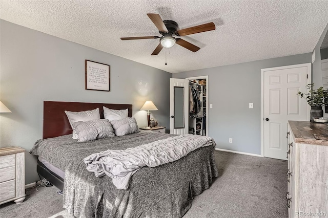 bedroom with baseboards, ceiling fan, a closet, a walk in closet, and carpet flooring