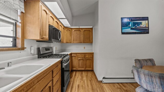 2923 Bonito Ave, Grand Junction, CO 81504 - kitchen featuring stainless steel range with gas cooktop, baseboard heating, light countertops, a sink, and light wood finished floors