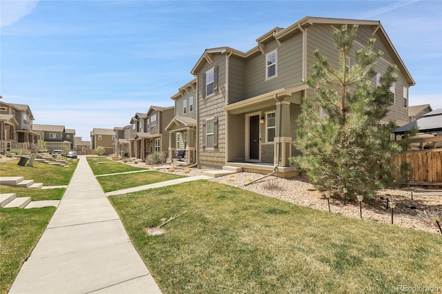 exterior space featuring a lawn, fence, and a residential view