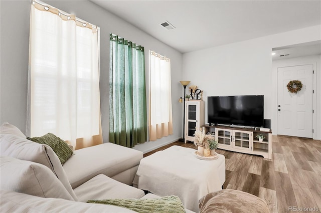 living area featuring wood finished floors and visible vents
