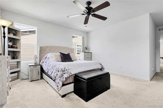 bedroom with baseboards, visible vents, a ceiling fan, and light colored carpet