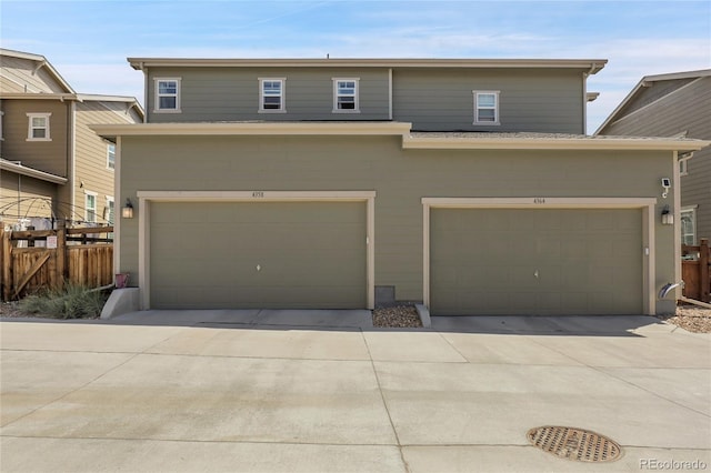 traditional home featuring a garage, fence, and driveway