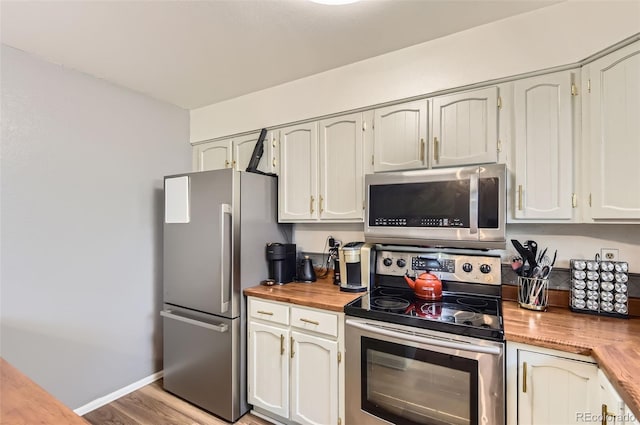16602 E Gunnison Pl, Aurora, CO 80017 - kitchen featuring appliances with stainless steel finishes, wood counters, light wood finished floors, and baseboards