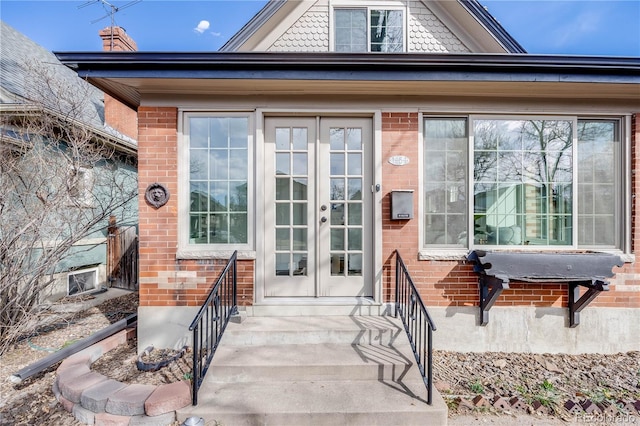 property entrance featuring french doors, brick siding, and cooling unit