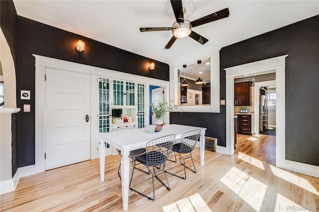 dining area with baseboards, light wood finished floors, and ceiling fan