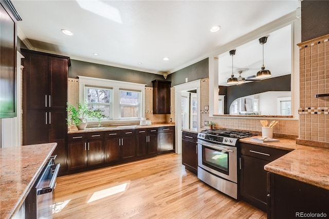 kitchen with light stone counters, stainless steel range with gas stovetop, ornamental molding, decorative backsplash, and light wood-type flooring