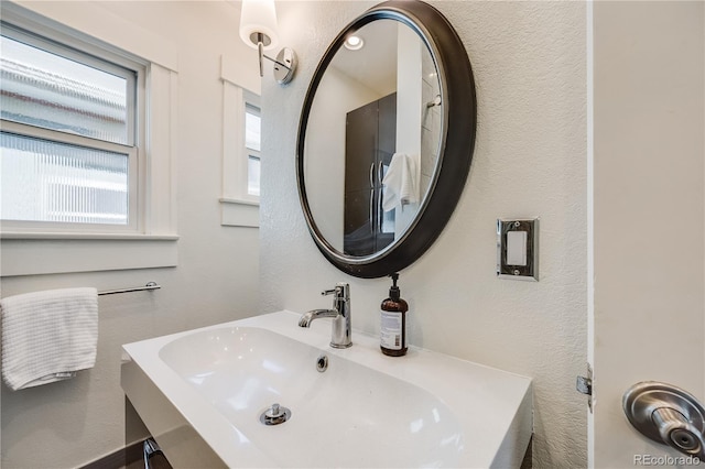 bathroom with a textured wall and a sink