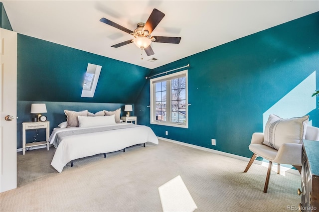 carpeted bedroom featuring visible vents, vaulted ceiling with skylight, a ceiling fan, and baseboards