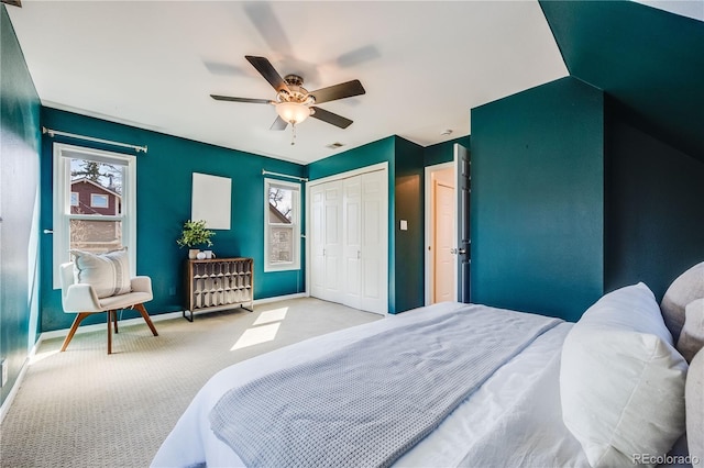 carpeted bedroom with visible vents, baseboards, a closet, and ceiling fan