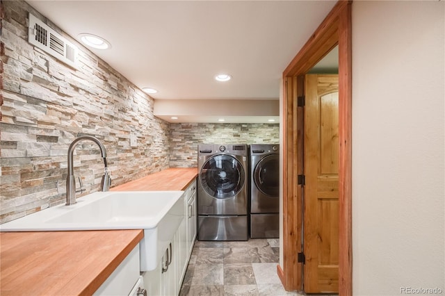 laundry area with visible vents, recessed lighting, washer and dryer, cabinet space, and a sink