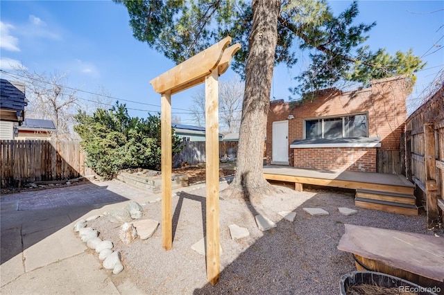 view of yard featuring a deck, a fenced backyard, and a patio area