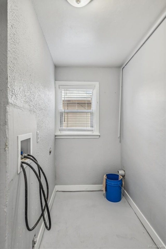 empty room featuring concrete floors and baseboards