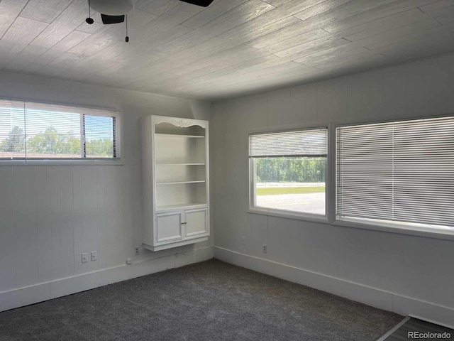 carpeted spare room with ceiling fan and wooden ceiling