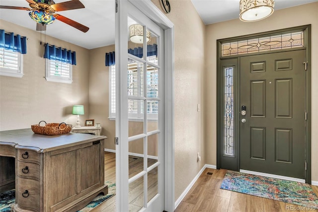 entrance foyer featuring light wood-type flooring, baseboards, and a ceiling fan