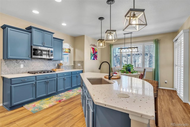 30 Stewart Way, Erie, CO 80516 - kitchen featuring a sink, light wood-type flooring, stainless steel appliances, and blue cabinetry