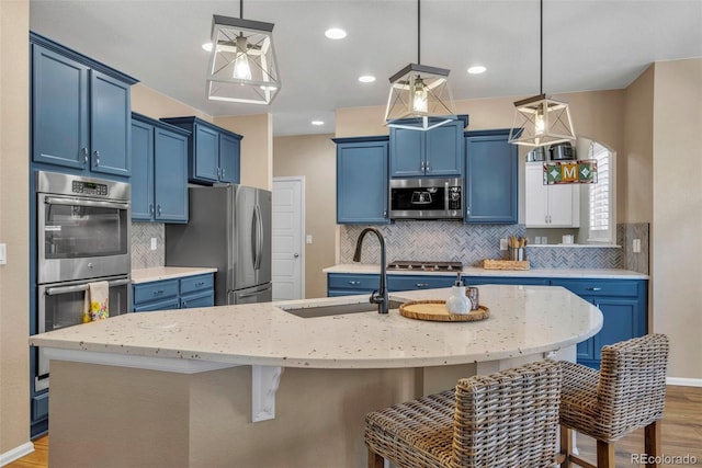 30 Stewart Way, Erie, CO 80516 - kitchen with a sink, a breakfast bar, blue cabinetry, and appliances with stainless steel finishes