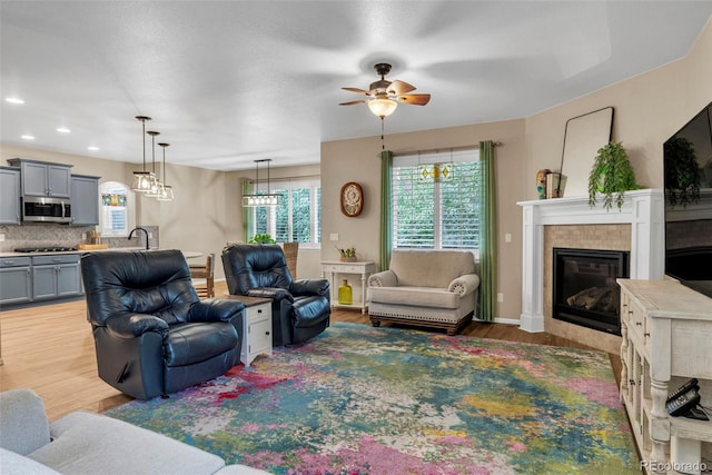 30 Stewart Way, Erie, CO 80516 - living room featuring recessed lighting, baseboards, ceiling fan, light wood-style floors, and a fireplace