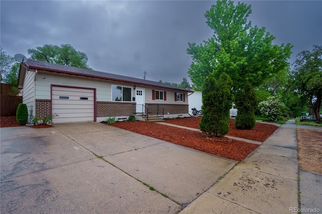 3118 E San Miguel St, Colorado Springs, CO 80909 - view of front of house featuring concrete driveway, an attached garage, and brick siding