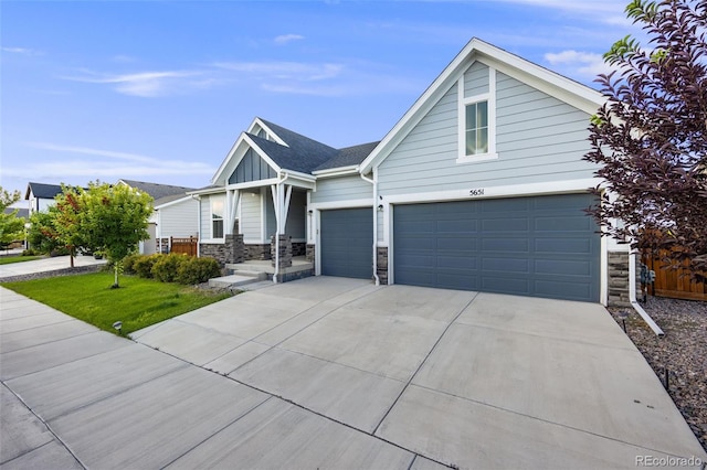 5651 Gore Creek Pl, Brighton, CO 80601 - view of front of home with stone siding, driveway, a garage, and board and batten siding
