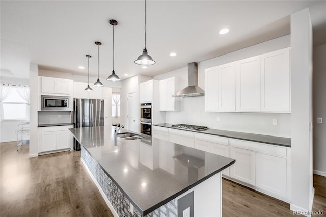 5651 Gore Creek Pl, Brighton, CO 80601 - kitchen featuring stainless steel appliances, wall chimney range hood, dark countertops, and recessed lighting