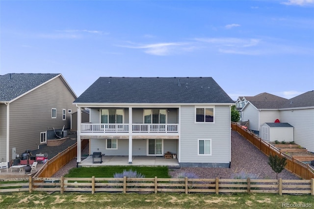 5651 Gore Creek Pl, Brighton, CO 80601 - rear view of house featuring a patio area, a fenced backyard, a shingled roof, and a balcony