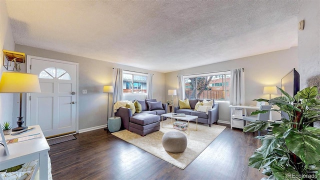 living room with a textured ceiling, dark hardwood / wood-style floors, and plenty of natural light