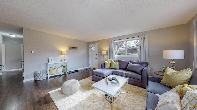 living room featuring a textured ceiling and dark wood-type flooring