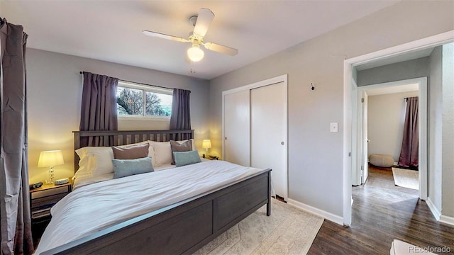 bedroom with wood-type flooring, ceiling fan, and a closet