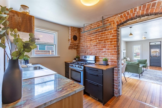604 W 1st St, Salida, CO 81201 - kitchen featuring gas range, butcher block countertops, light wood-style floors, and a sink