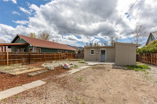 604 W 1st St, Salida, CO 81201 - back of house with a fenced backyard, a patio, and a vegetable garden